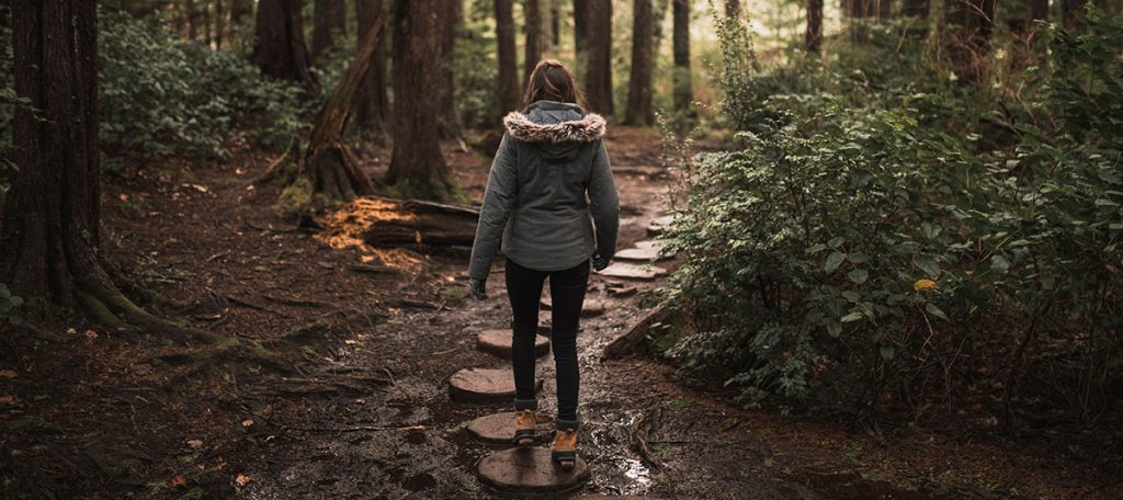woman forest stepping stones